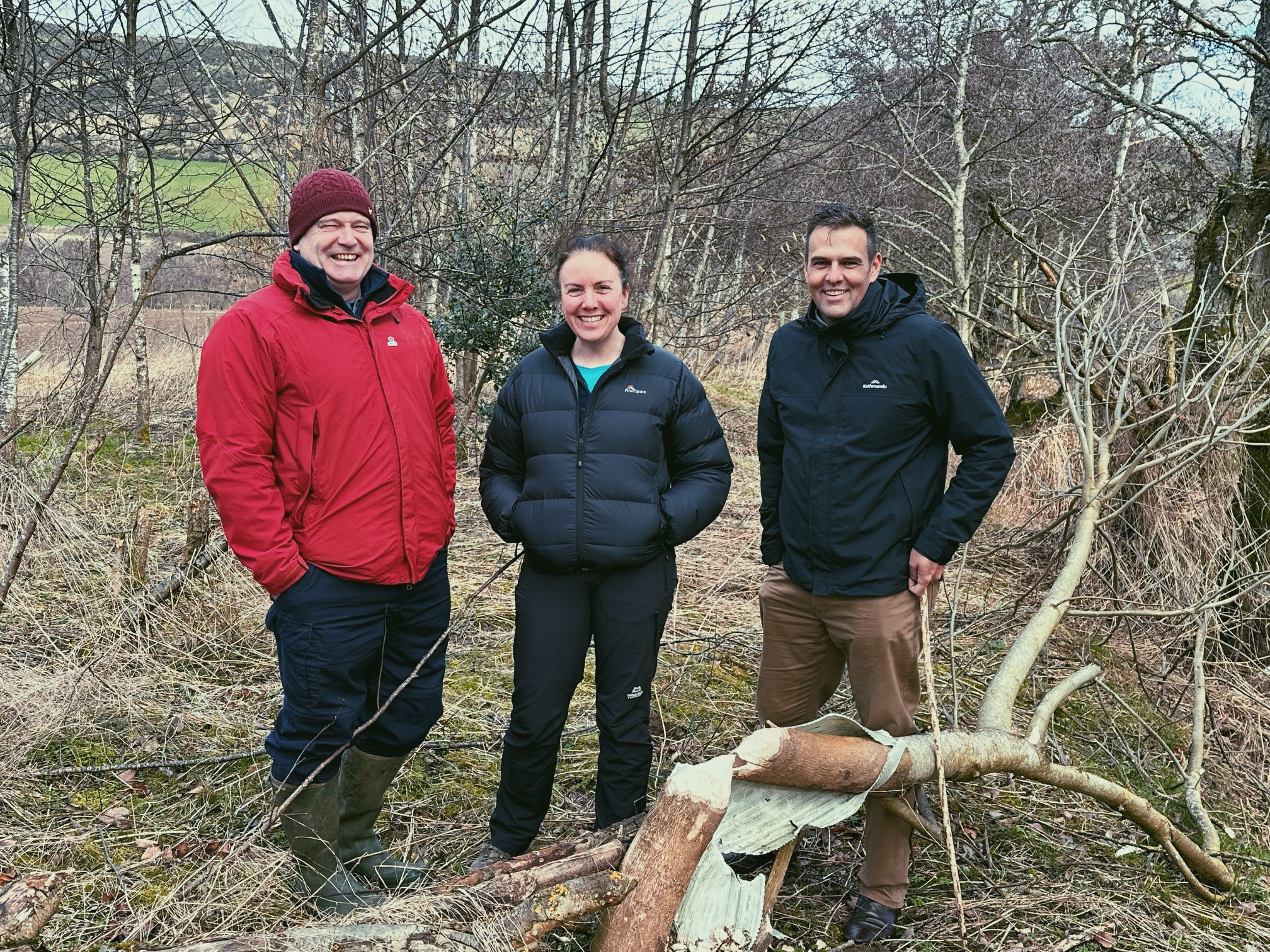 Group standing behind a beaver felled tree